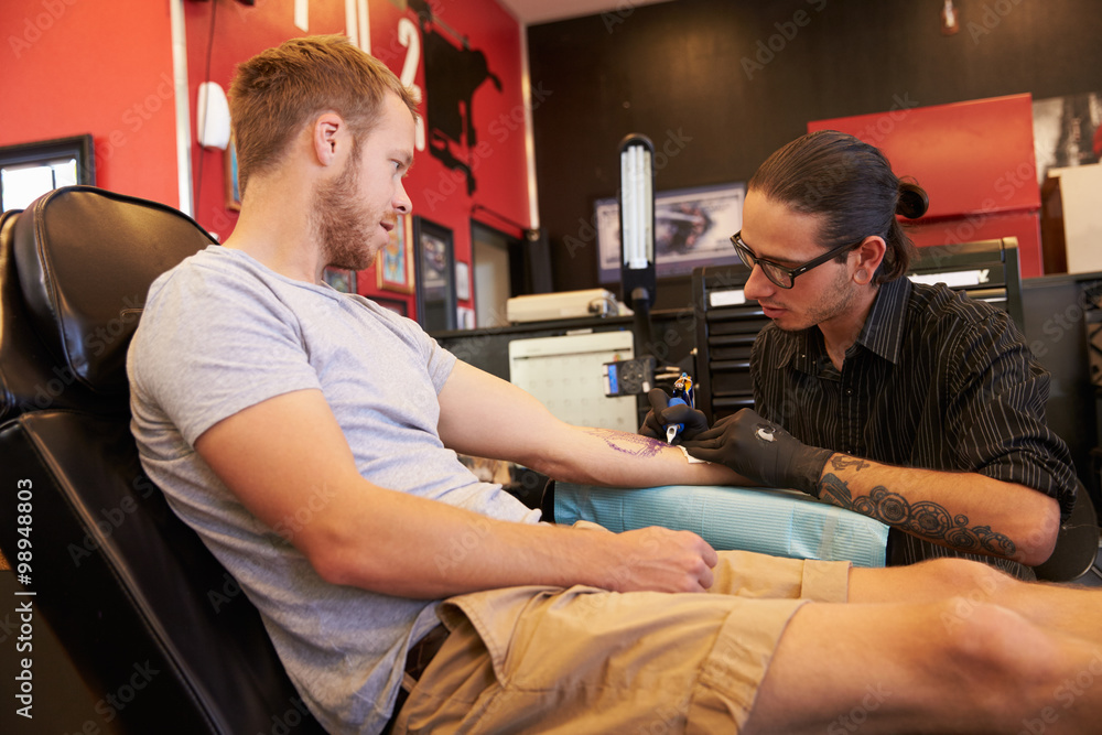 Peter tattooing a client's arm